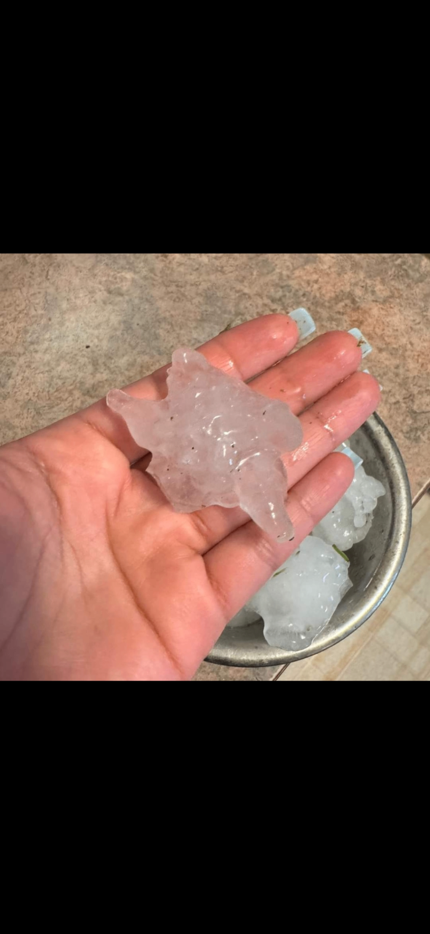 Giant jagged hailstone held in hand